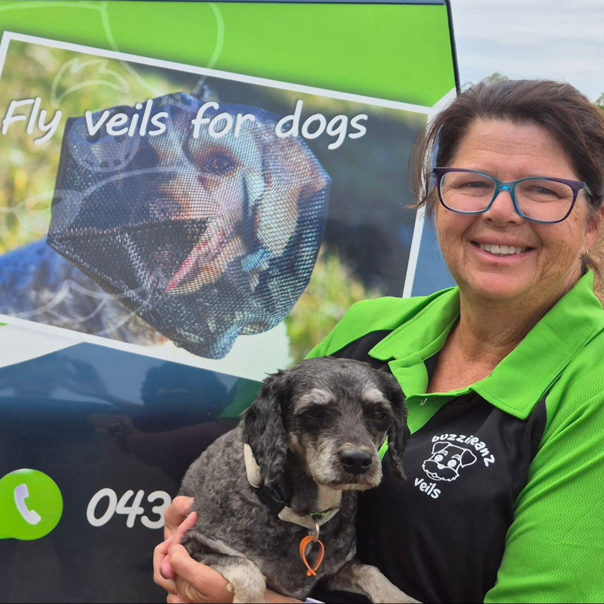 Person holding a dog next to a vehicle with buzzibeanz veils branding